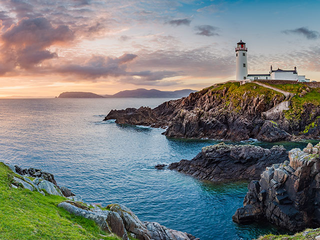 coast with lighthouse on cliffs