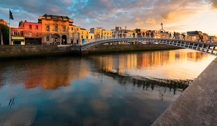 bridge over a river is the focal point and a row of buildings on the left stretching into the backgorund going toward the right side